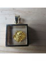 Très joli pendentif présentant une feuille d'or sous verre;