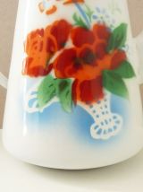 Théière émaillée blanche aux motifs floraux, rustique.