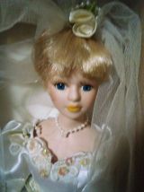 vends une ancienne poupée en porcelaine dans un robe de mari