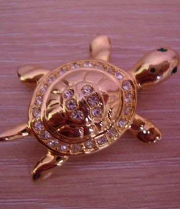 Broche vintage "tortue" en métal doré garnie de strass