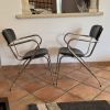 Lot de 2 chaises vintage. 1960. Pieds compas et skaï noir