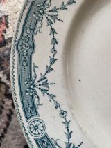 3 assiettes plates terre de fer à la bordure fleurie verte.