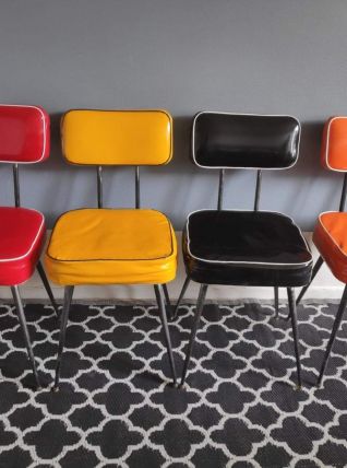 chaises vintage en vinyle noire, jaune, orange et rouge